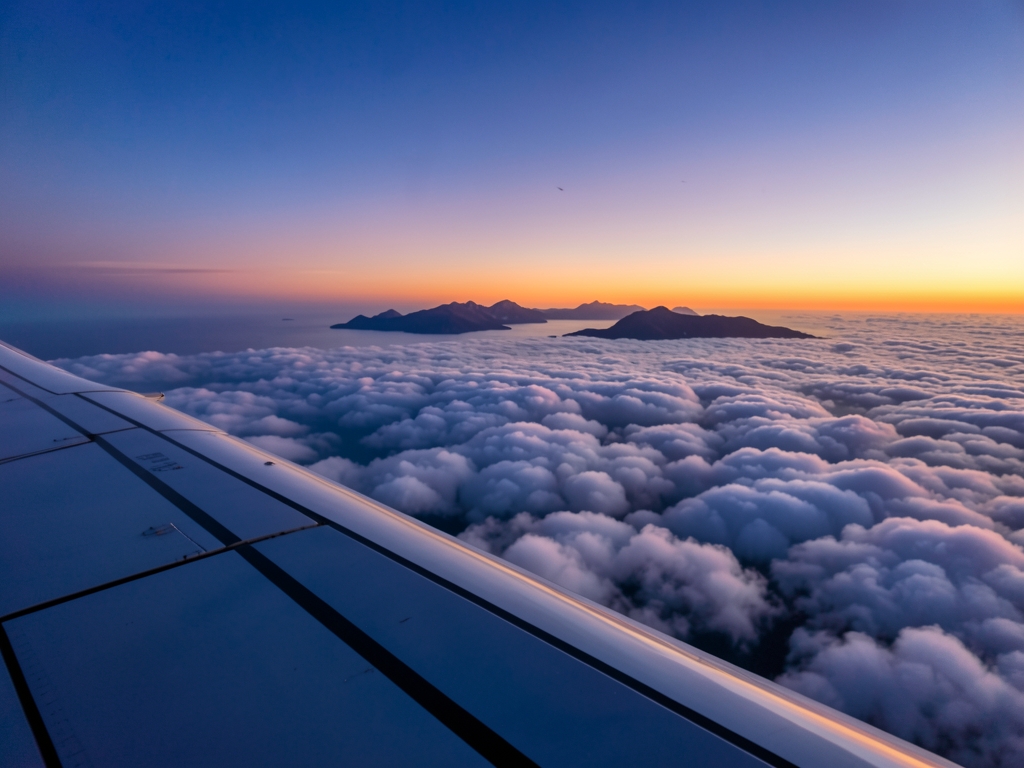 Aerial view from airplane window sunset silver wing