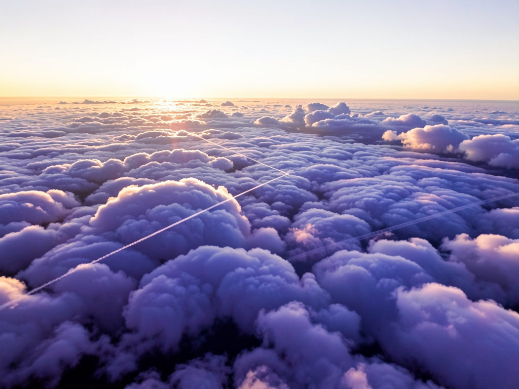 Aerial winter journey above cloud deck pale gold sun