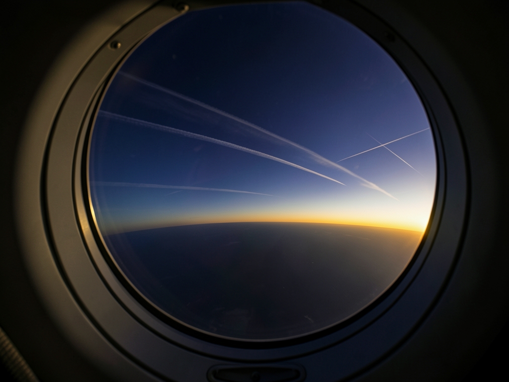Ethereal view through aircraft porthole capturing curvature earth