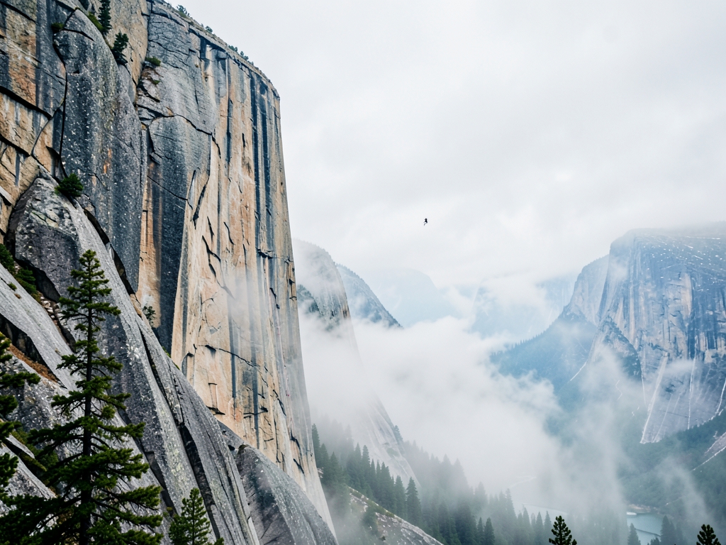 Overcast hangs above distant climber s tiny silhouette ascending