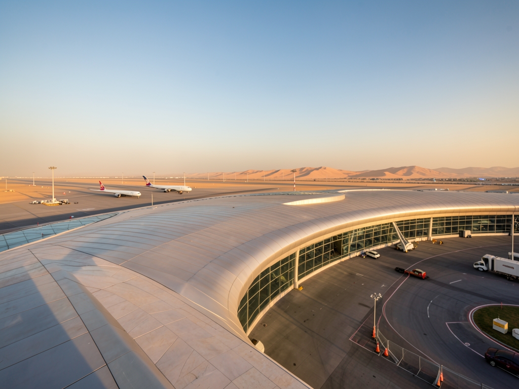 Curving Doha airport terminal soft desert sunlight limestone