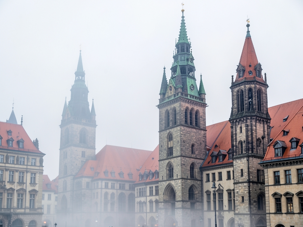 Morning mist clings historic stone towers red tiled roofs