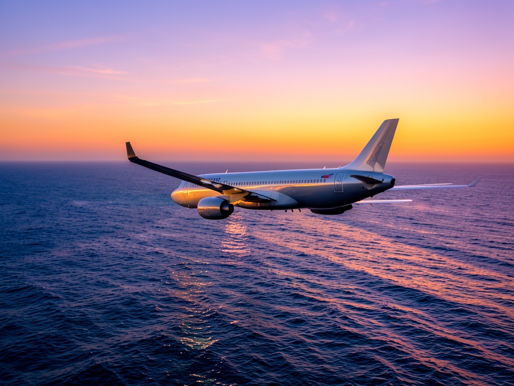 sleek commercial glides over Atlantic Ocean sunset casting