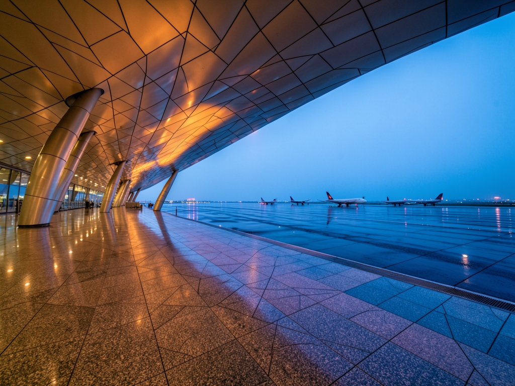 modern Beijing airport terminal dusk with sweeping curved